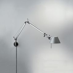 a lamp that is on the wall with a white light behind it and a gray background