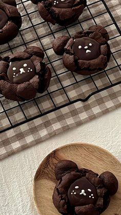 chocolate cookies with white sprinkles are on a plate next to a cooling rack