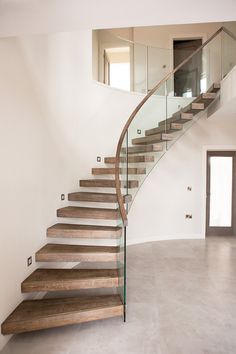 there is a staircase with glass balustrades and wood steps in the house