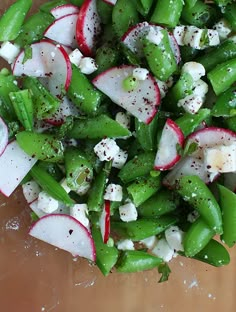 a salad with radishes, cucumbers and feta cheese on it