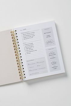 an open planner book on top of a white table