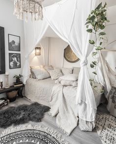 a bed with white sheets and pillows in a room next to pictures on the wall