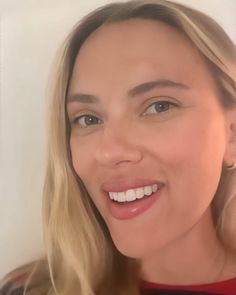 a close up of a person wearing a red shirt and smiling at the camera with white teeth