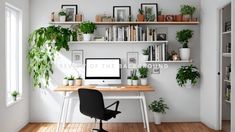 there is a desk with a computer on it and some potted plants in the corner