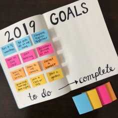 a book with sticky notes on it and the words goals written in different colors next to each other