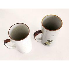 two coffee mugs sitting next to each other on a table