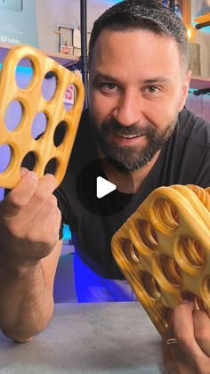 a man holding up a yellow object with holes in it