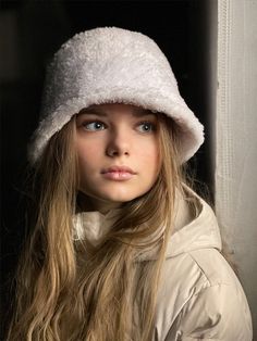 a woman with long hair wearing a white hat