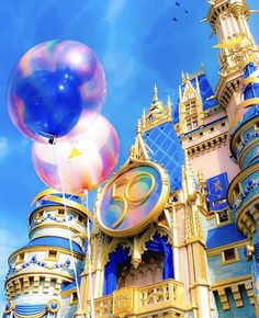 an image of a castle with balloons floating in the air at disney world's magic kingdom