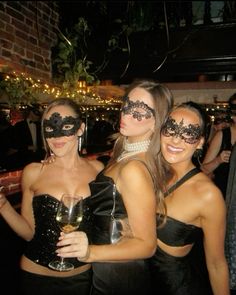 three women in masquerades pose for the camera