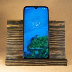 an iphone sitting on top of a wooden stand