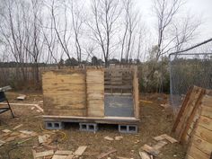 several wooden pallets stacked on top of each other in a yard next to a chain link fence