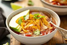 two bowls filled with taco soup on top of a wooden table