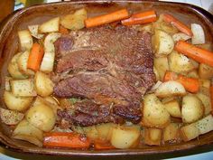 a roast beef with carrots and potatoes in a casserole dish