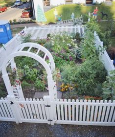 an aerial view of a garden with white fences