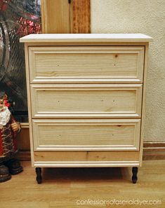 a white dresser sitting on top of a hard wood floor next to a christmas tree