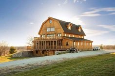 a large wooden house sitting on top of a lush green field