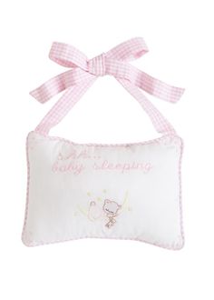 a pink and white pillow with a bow on it