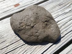 a rock sitting on top of a wooden bench