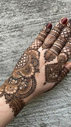 a woman's hand with henna tattoos on it