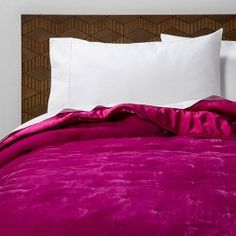 an unmade bed with white pillows and fuchsia pink comforter on it