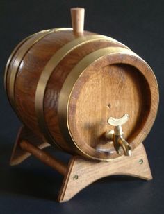 a wooden wine barrel on a stand with a cork