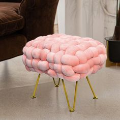 a stool made out of pink marshmallows in a living room with a brown chair