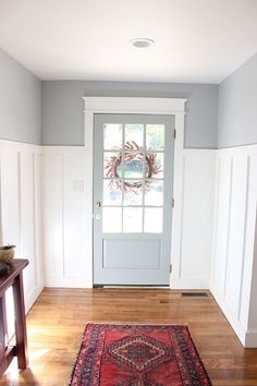 an empty room with a door and rug on the floor