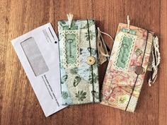 three pieces of fabric sitting on top of a wooden table next to an envelope and some string