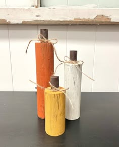 three different colored wooden poles tied with twine