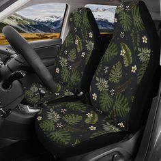 the interior of a car is decorated with green leaves and white flowers on black fabric