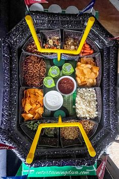 a tray filled with lots of different types of food next to chips and dips