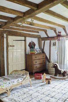 a bedroom with wooden beams and an animal bed on the floor in front of it