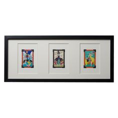 three framed pictures hanging on the wall with black frames and white backings, each featuring different colored images