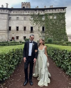 a man in a tuxedo standing next to a woman in a wedding dress