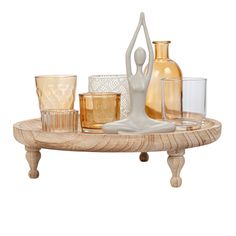 a wooden tray topped with glasses and vases