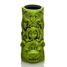 a green ceramic vase with two faces on it