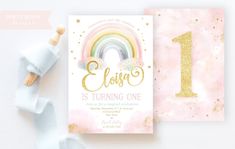 a pink and gold first birthday party card with a rainbow on the front, one is turning 1