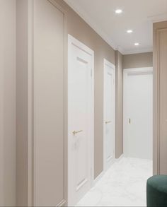 an empty room with two white doors and a green stool in the middle of it