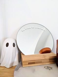 there is a mirror and some other items on the table with ghost decorations around it