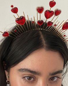 a close up of a person wearing a tiara with hearts on it's head