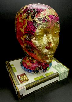 a gold mask sitting on top of a stack of money