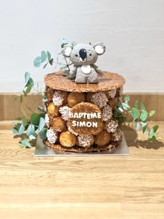 a cake made to look like a koala bear sitting on top of some doughnuts