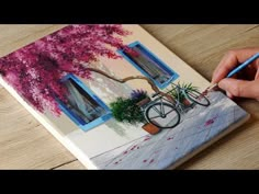 a person is drawing on a piece of paper with a pencil and watercolors