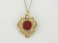 The style of this antique pin is romantic and natural, classical Art Nouveau with the curving lines and elegant grace that the era is known for. Small cultured pearls provide points of light around the frame, which can be worn as a pendant or brooch. We've set an appropriate stone into this setting, a carnelian gemstone that is carved intaglio with a soldier of Ancient Rome. This pendant does not come with the chain shown. Please feel free to contact us, we will help you find the perfect chain for your style and budget! Metal: 14K Yellow Gold Gem: Carved Carnelian Intaglio Gem Measurements: 15 mm, Round Accents: Seed Pearls Measurements: 38 x 33 mm Marks: "14K" Stamped on the Reverse Antique Pins, A Soldier, Classical Art, Seed Pearl, Ancient Rome, Antique Art, Cultured Pearls, Eternity Bands, Rome