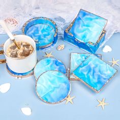 blue and white coasters with starfish designs on them next to a cup of coffee