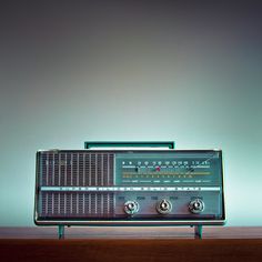 an old fashioned radio sitting on top of a wooden table in front of a wall