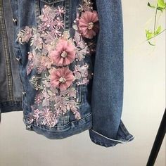 a denim jacket with pink flowers on it