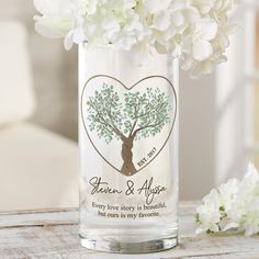 a vase filled with white flowers on top of a wooden table