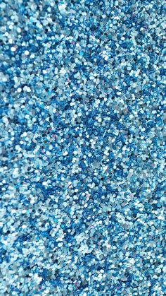 blue glitter textured background with lots of small sparkles on it's surface